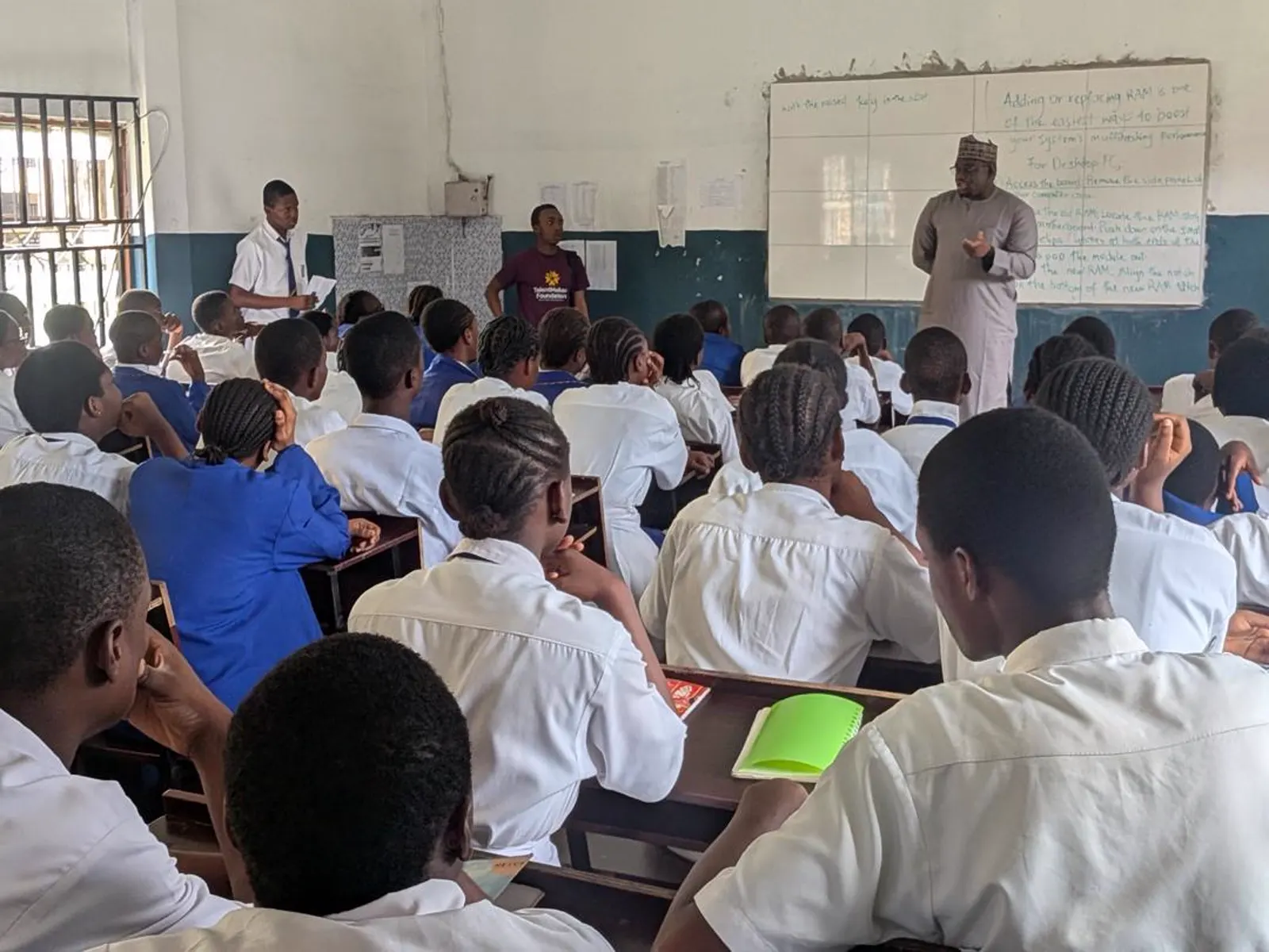 A TalentMakers Foundation volunteer and facilitator teaching a RAM upgrade lesson at the whiteboard