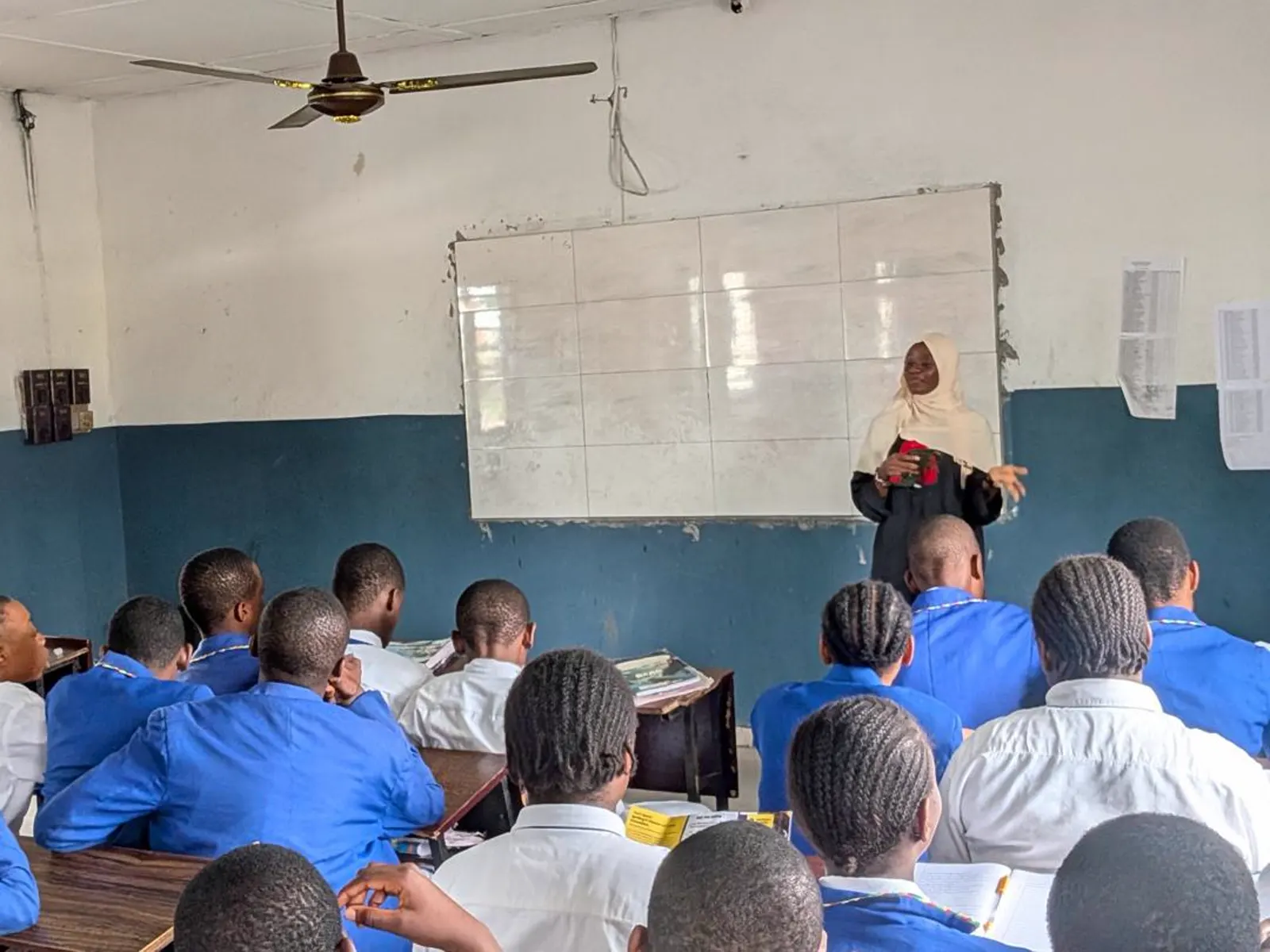 A female facilitator leading a TechSpark classroom session at the whiteboard