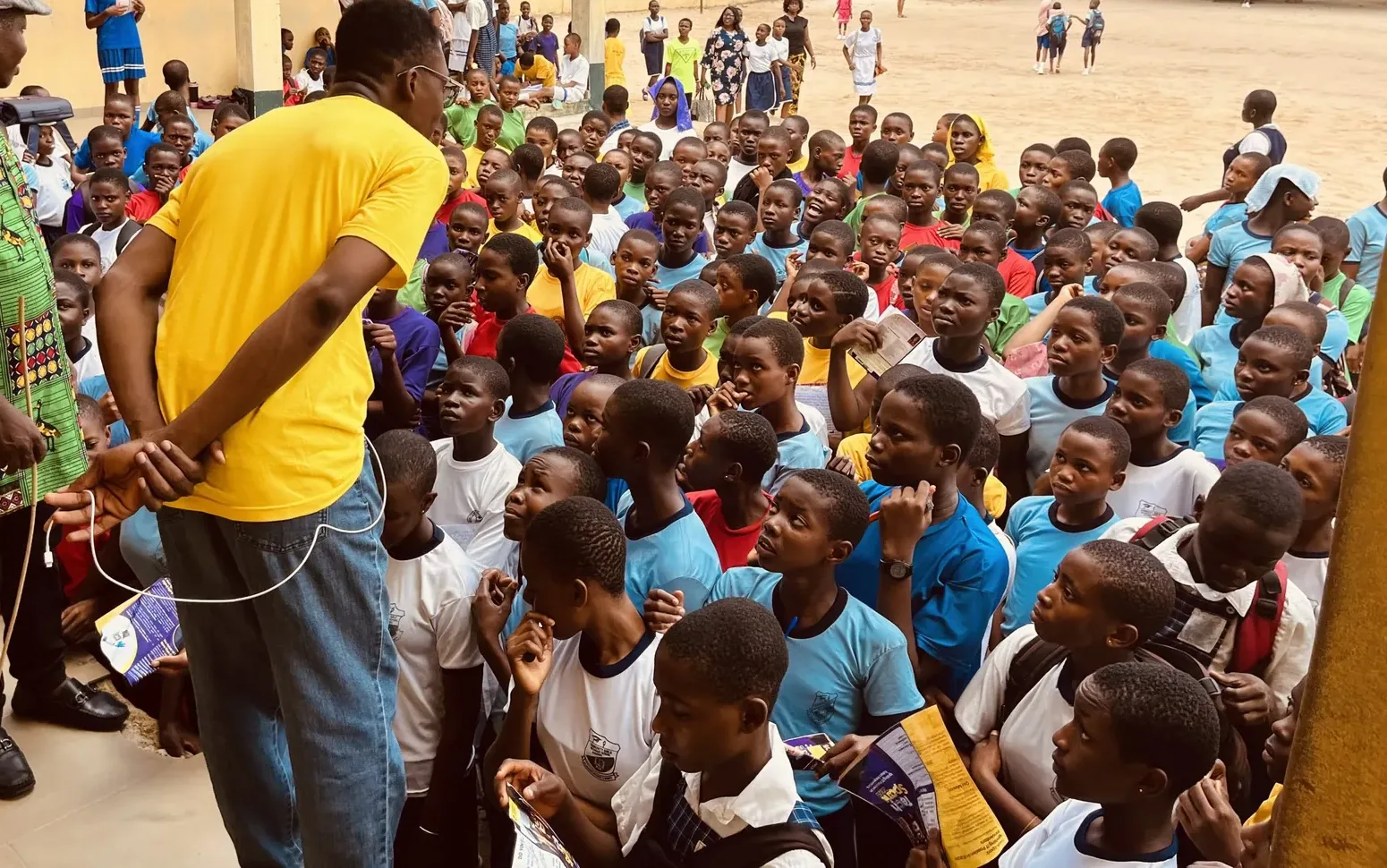 A packed assembly of students listening to a TechSpark briefing in a school yard
