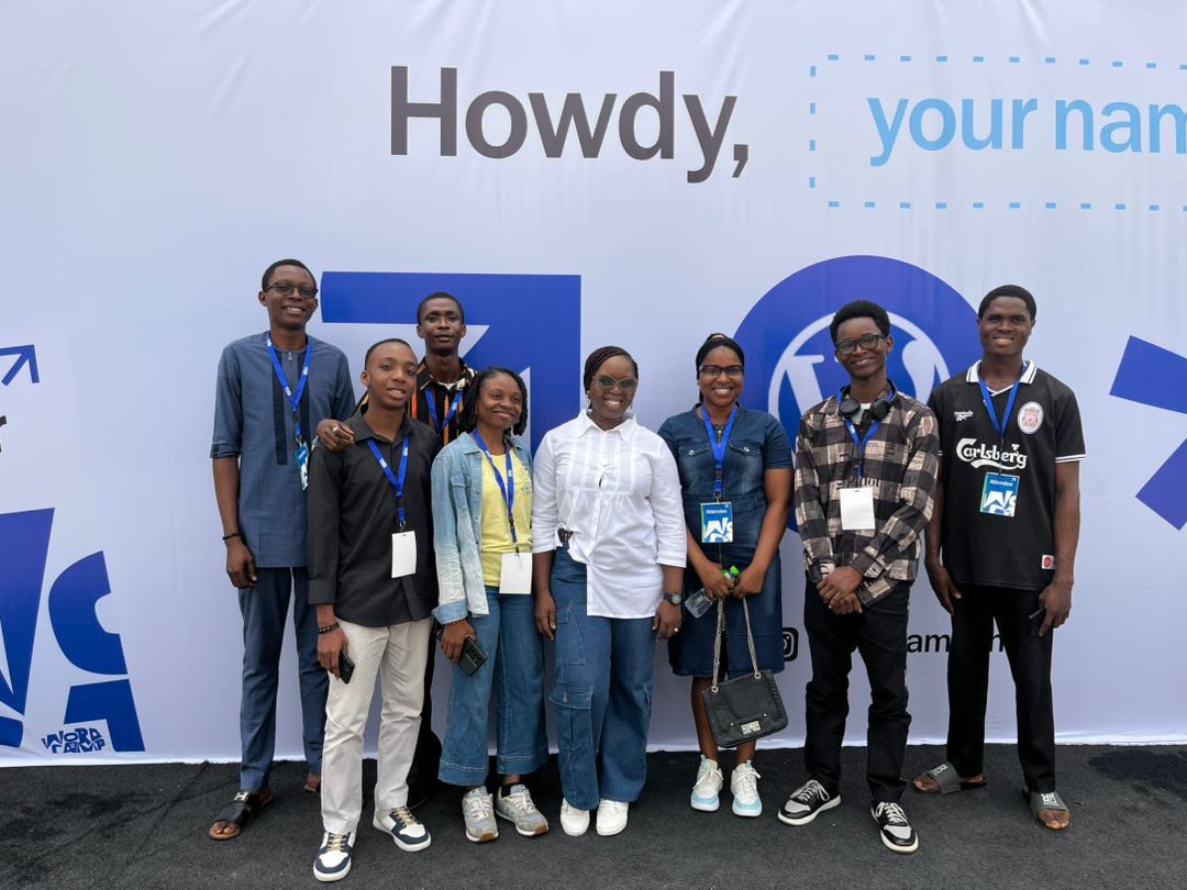 Scholars and staff at the WordCamp welcome backdrop
